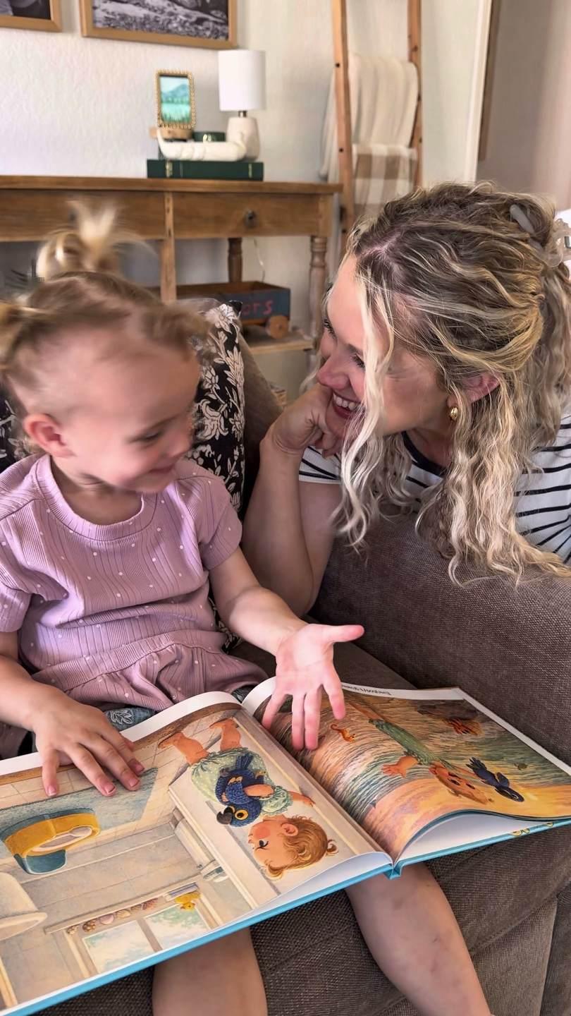 Isla and her mom reading her personalized storybook together on the couch