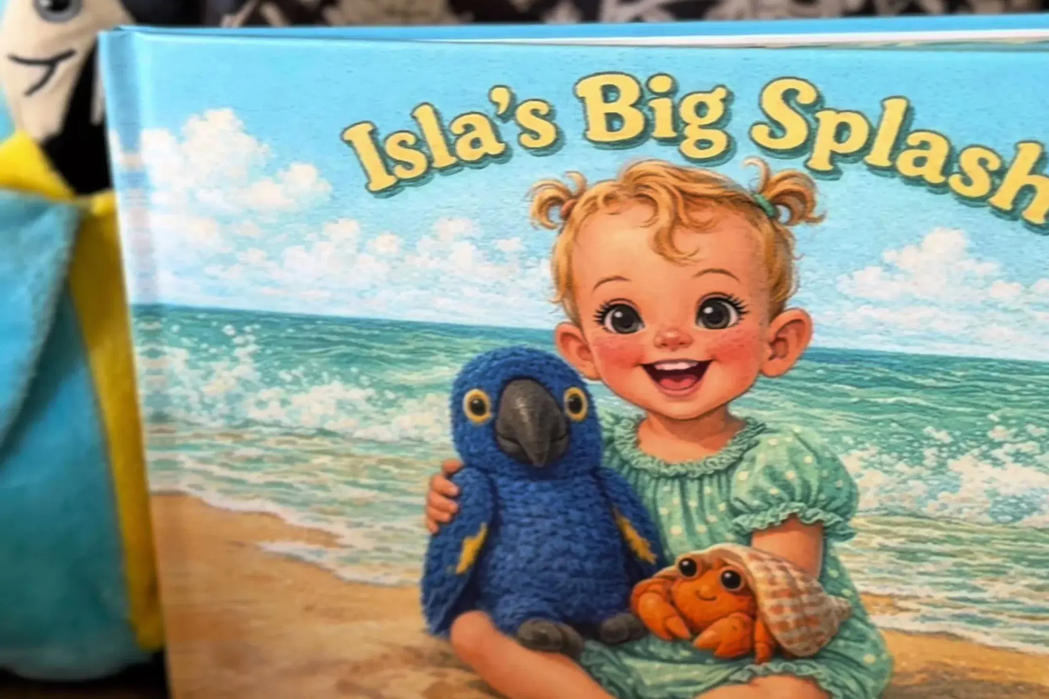 Isla’s real blue macaw plush beside her book cover, where the same macaw is drawn next to her